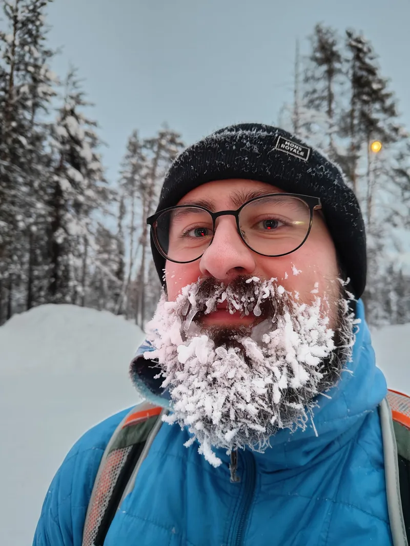 Nick with a beard full of frost on a snowy fell in Lapland